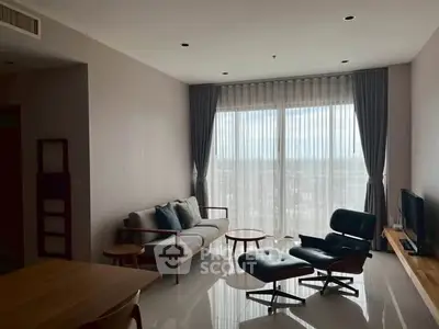 Stylish modern living room with chic furniture and large window view.