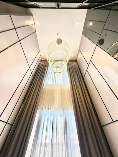 Stunning modern interior with high ceilings and elegant lighting fixtures.