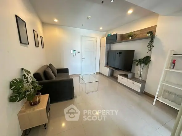 Modern living room with sleek furniture and large TV, perfect for relaxation and entertainment.