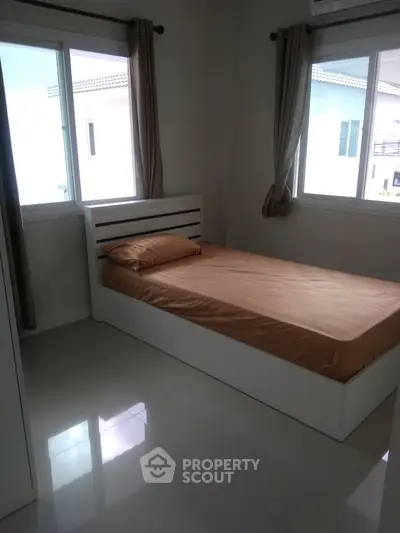 Cozy bedroom with natural light and modern furnishings in a stylish home.