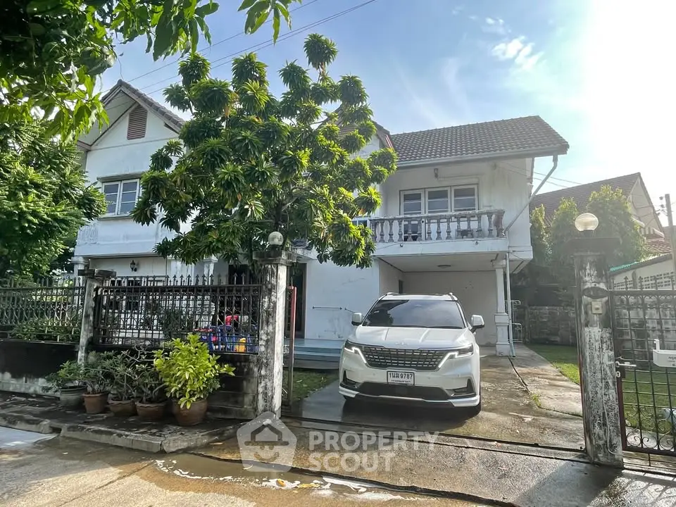 Charming suburban house with lush greenery and spacious driveway, perfect for family living.