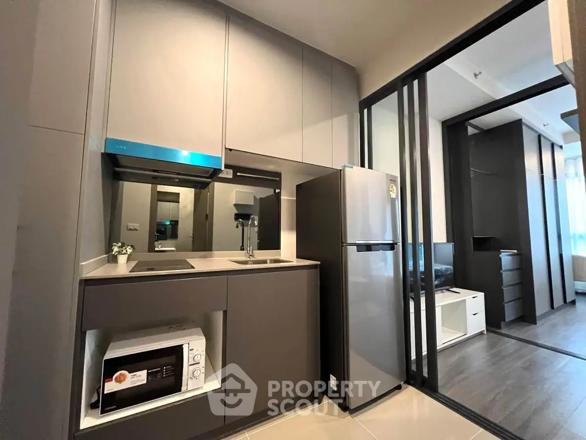 Modern kitchen with sleek cabinetry and stainless steel appliances in a stylish apartment.