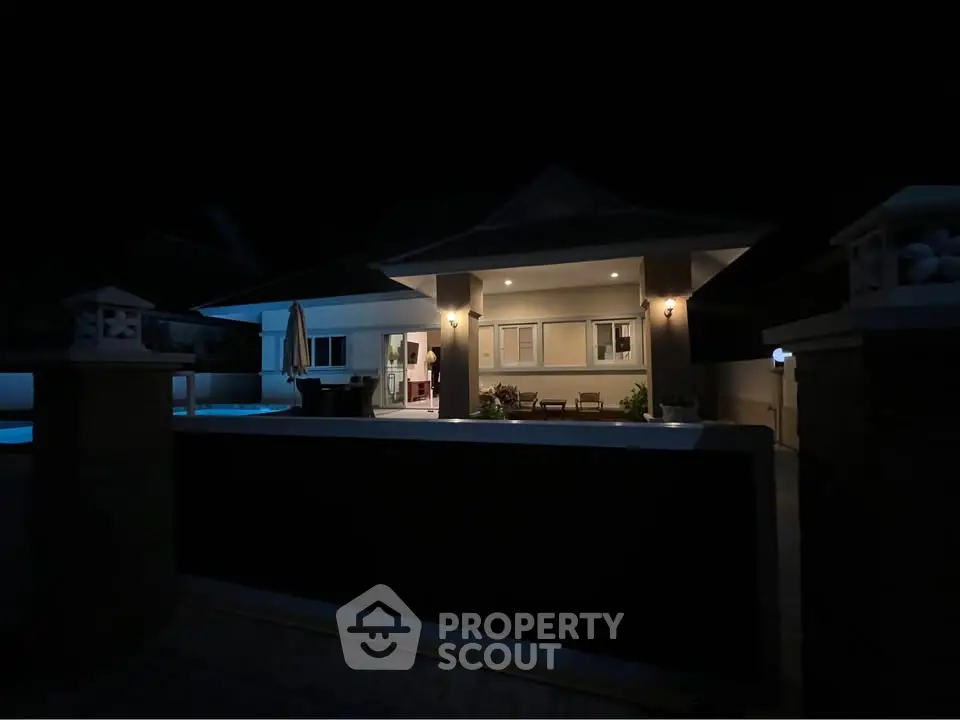 Stunning night view of a modern home with illuminated pool and patio area, perfect for luxurious living.