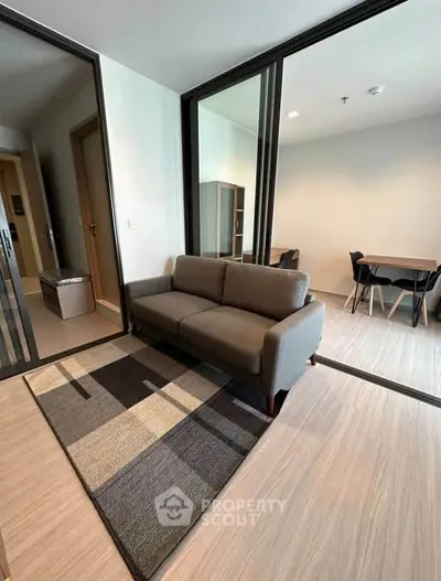 Modern living room with stylish sofa and dining area in open layout apartment.