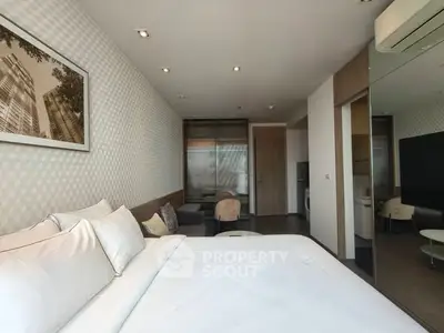 Modern bedroom with stylish decor and cozy seating area in a luxury apartment.