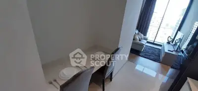 Modern living room with dining area and city view, featuring sleek furniture and large windows.