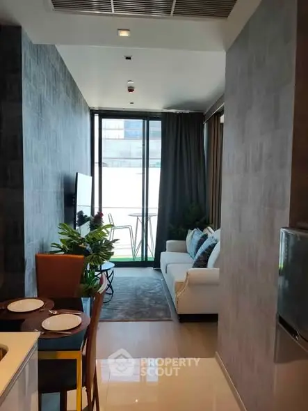 Modern living room with balcony view, stylish decor, and open layout in urban apartment.