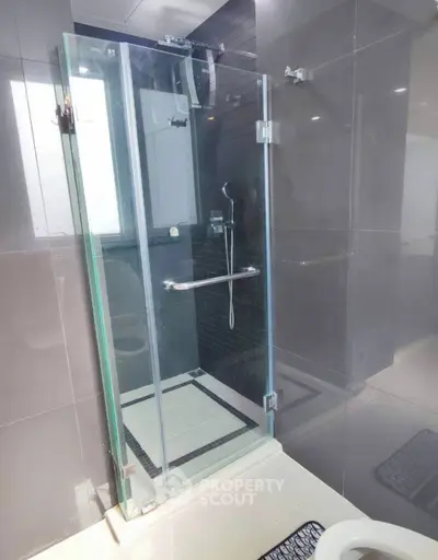 Modern bathroom with sleek glass shower enclosure and elegant tile design.