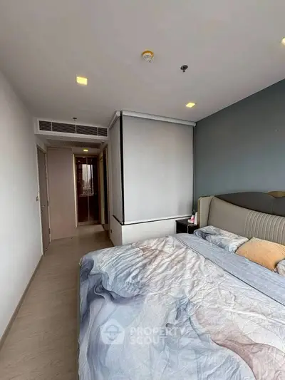 Modern bedroom with stylish decor and cozy bedding in a contemporary apartment.