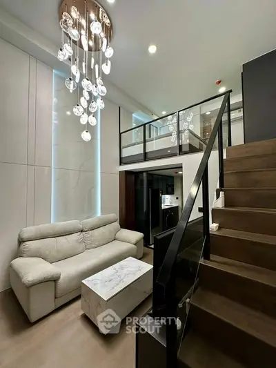 Modern loft apartment with elegant chandelier and stylish staircase