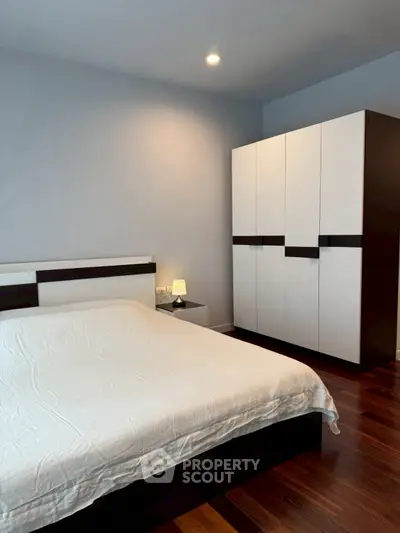 Modern bedroom with sleek wardrobe and cozy lighting, perfect for relaxation.