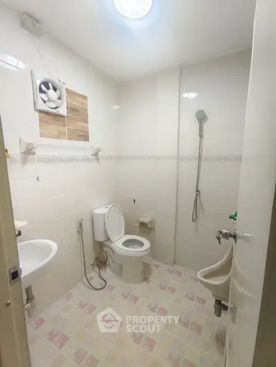 Spacious bathroom with modern fixtures and tiled flooring in a contemporary home.