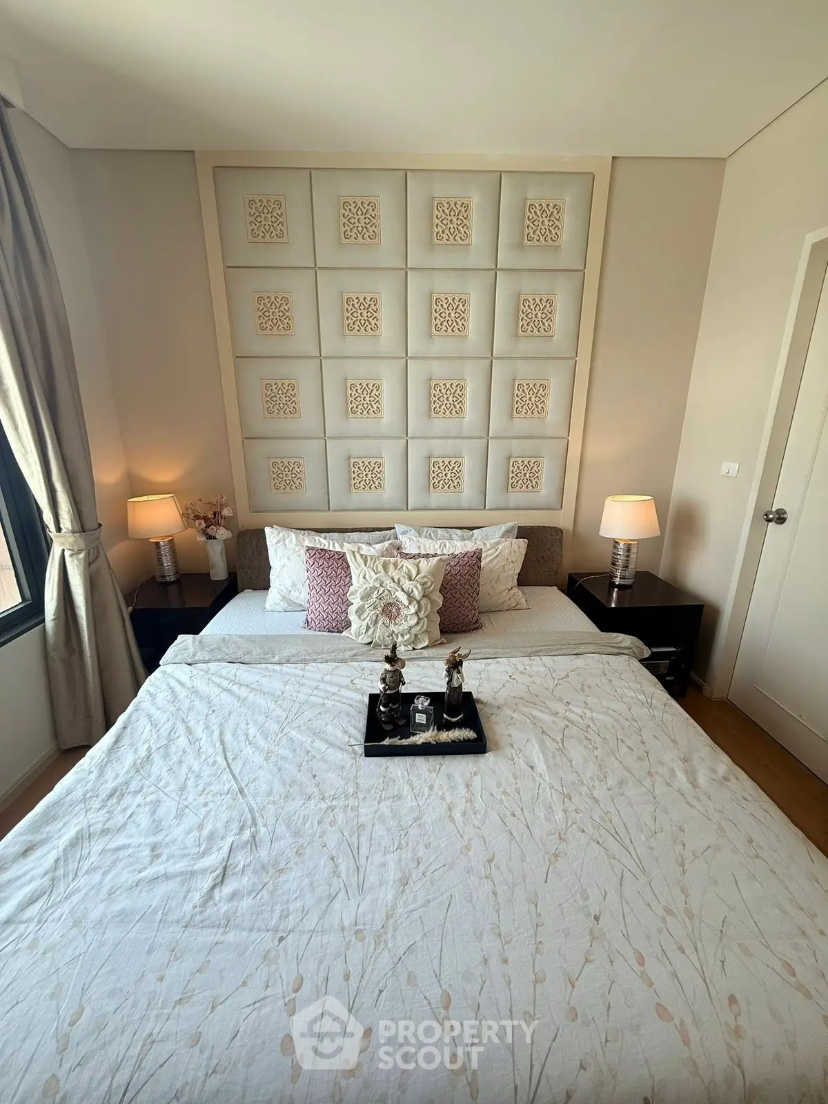 Luxurious bedroom with elegant decor and plush bedding in a modern apartment.