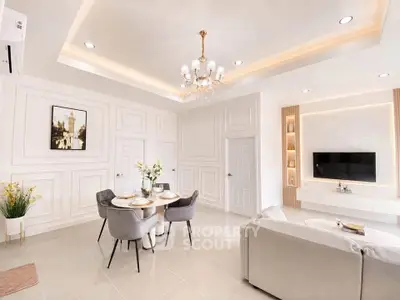 Elegant living room with chandelier, modern decor, and cozy dining area in a luxurious apartment.