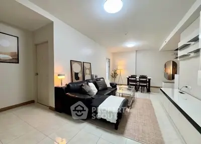 Spacious modern living room with sleek black sofa and elegant dining area