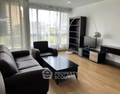 Spacious living room with modern furniture and large windows offering natural light.