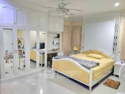 Spacious bedroom with elegant white furniture and ample storage space