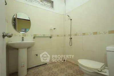 Spacious bathroom with modern fixtures and tiled flooring in a real estate property.