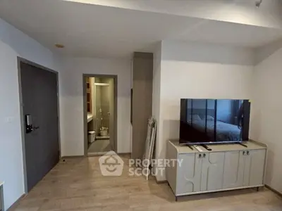 Modern living room with TV and bathroom entrance, stylish interior design