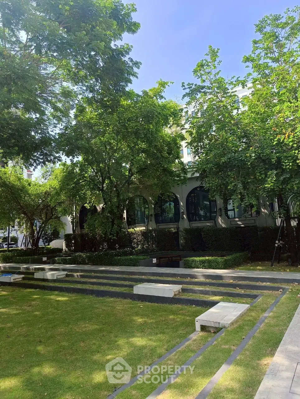 Lush garden area with modern seating and mature trees, perfect for relaxation.