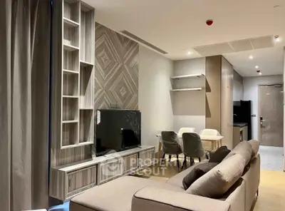 Modern living room with stylish decor and open layout, featuring a cozy sofa and sleek entertainment center.