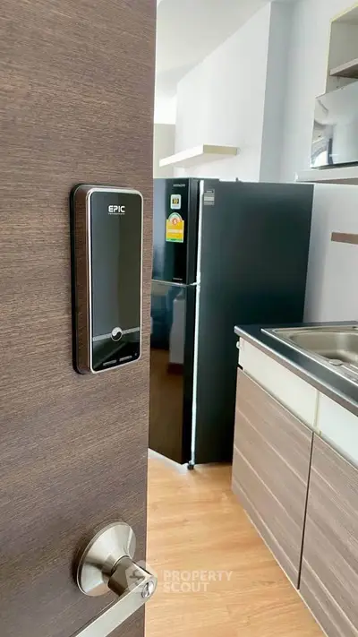 Modern kitchen with sleek appliances and digital door lock for enhanced security.