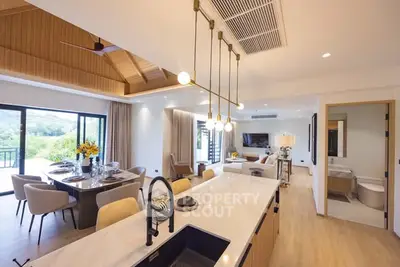 Luxurious open-plan living room and kitchen with elegant dining area and scenic views.
