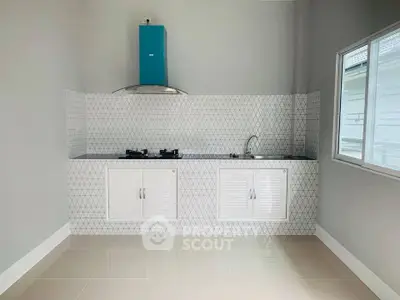 Modern kitchen with gas stove and sleek white cabinets in a bright, airy space.