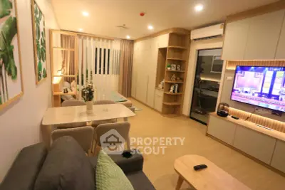 Modern living room with stylish decor and open layout, featuring a cozy dining area and entertainment setup.