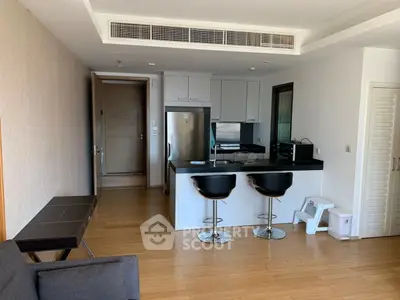 Modern open-layout kitchen with sleek design and bar seating in a stylish apartment.