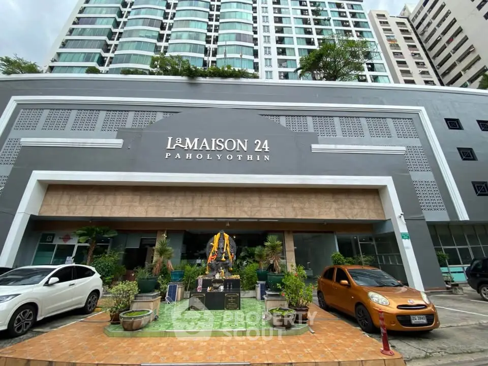 Modern condominium entrance with stylish facade and parked cars at La Maison 24 Paholyothin.