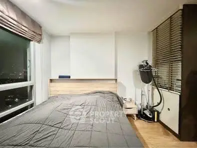 Modern bedroom with large window offering city view, sleek design and cozy ambiance.