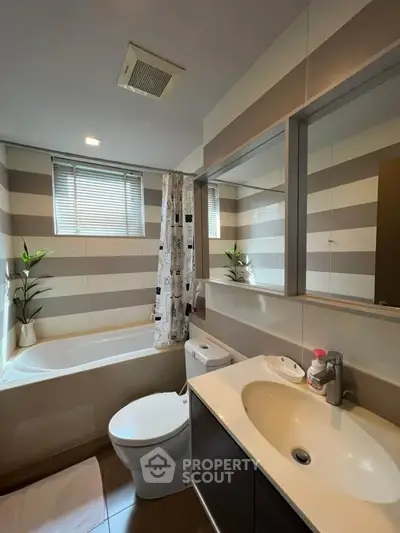 Modern bathroom with bathtub and stylish striped walls