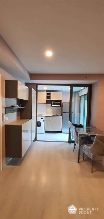 Modern open-plan kitchen and dining area with sleek cabinetry and appliances.