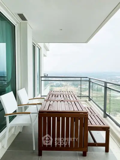 Spacious balcony with wooden furniture and stunning panoramic view.