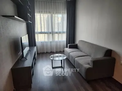 Modern living room with sleek furniture and city view from large window.