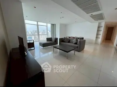 Spacious modern living room with city view and sleek furnishings.