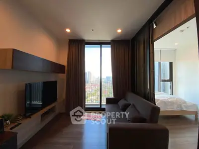 Modern living room with large window and city view, featuring sleek furniture and cozy ambiance.