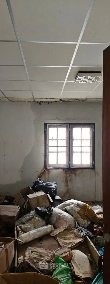 Room with cluttered boxes and bags, showing potential for renovation and improvement.