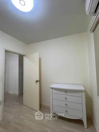 Cozy bedroom with elegant white dresser and soft lighting, perfect for a serene retreat.