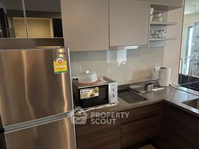 Modern kitchen with stainless steel fridge and microwave in sleek apartment