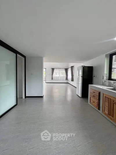 Spacious open-plan living area with modern kitchen and large windows for natural light.