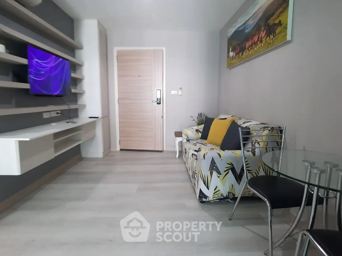 Modern living room with stylish decor and wall-mounted TV in a cozy apartment.