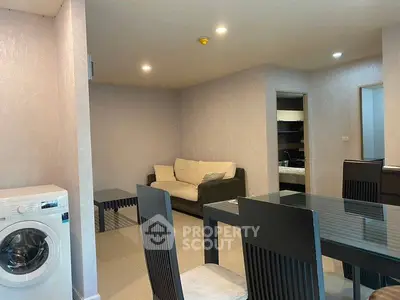 Modern living room with dining area and washing machine in stylish apartment.
