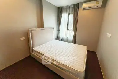 Modern bedroom with stylish bed and air conditioning in a well-lit apartment.