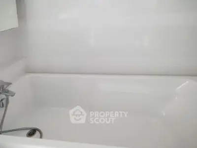 Modern bathroom with sleek white bathtub and chrome fixtures, perfect for relaxation.