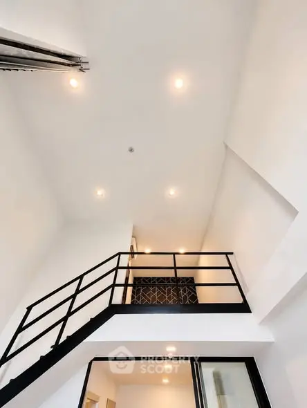 Modern minimalist interior with high ceiling and sleek staircase design