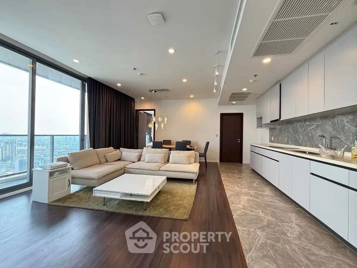 Luxurious open-layout living room with panoramic city view and modern kitchen.
