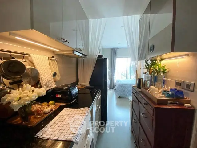 Charming kitchen with modern appliances leading to a cozy bedroom, perfect for urban living.