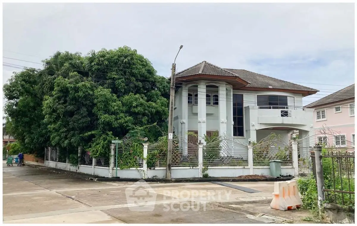 Charming two-story house with lush greenery and modern architecture in a serene neighborhood.